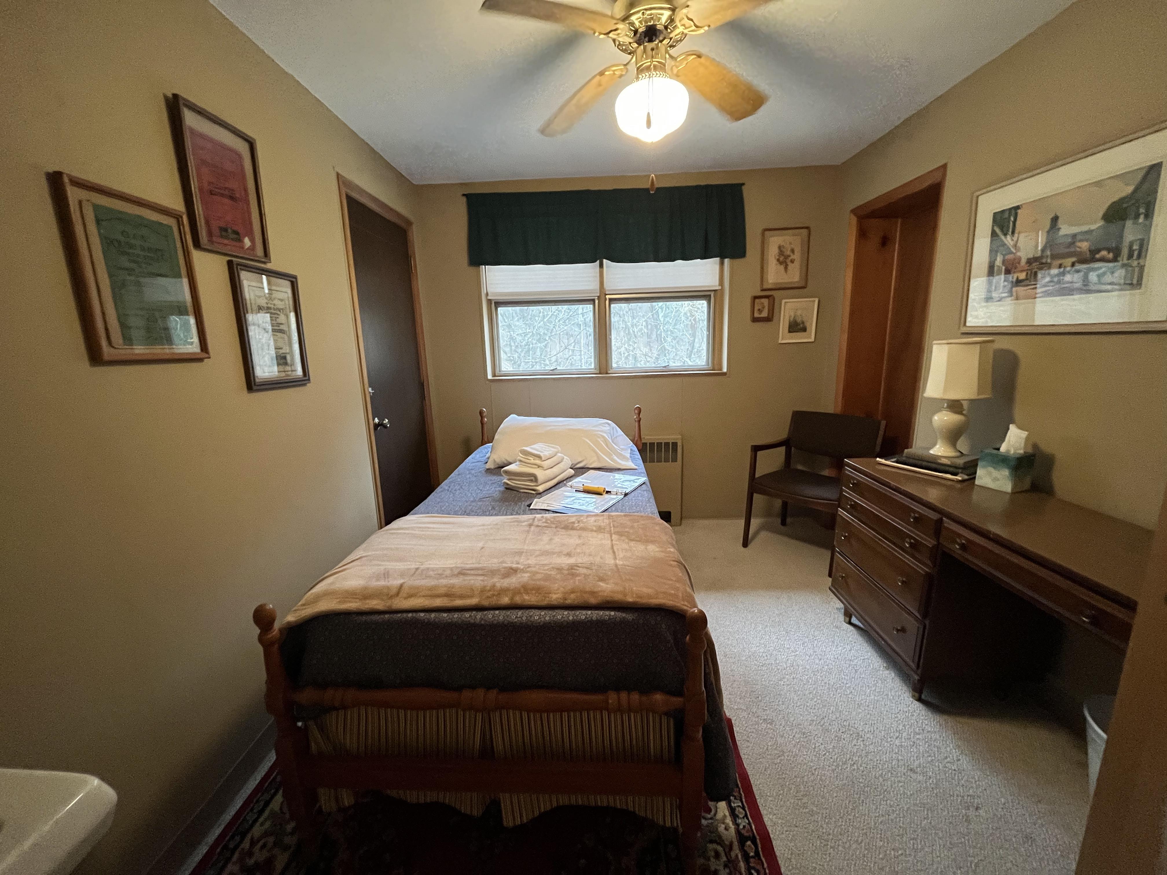East Wing bedroom with single bed, desk, and ceiling fan